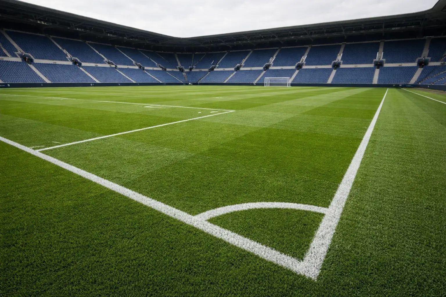 Een professioneel voetbalveld met groene grasmat klaar voor een Eredivisie-wedstrijd